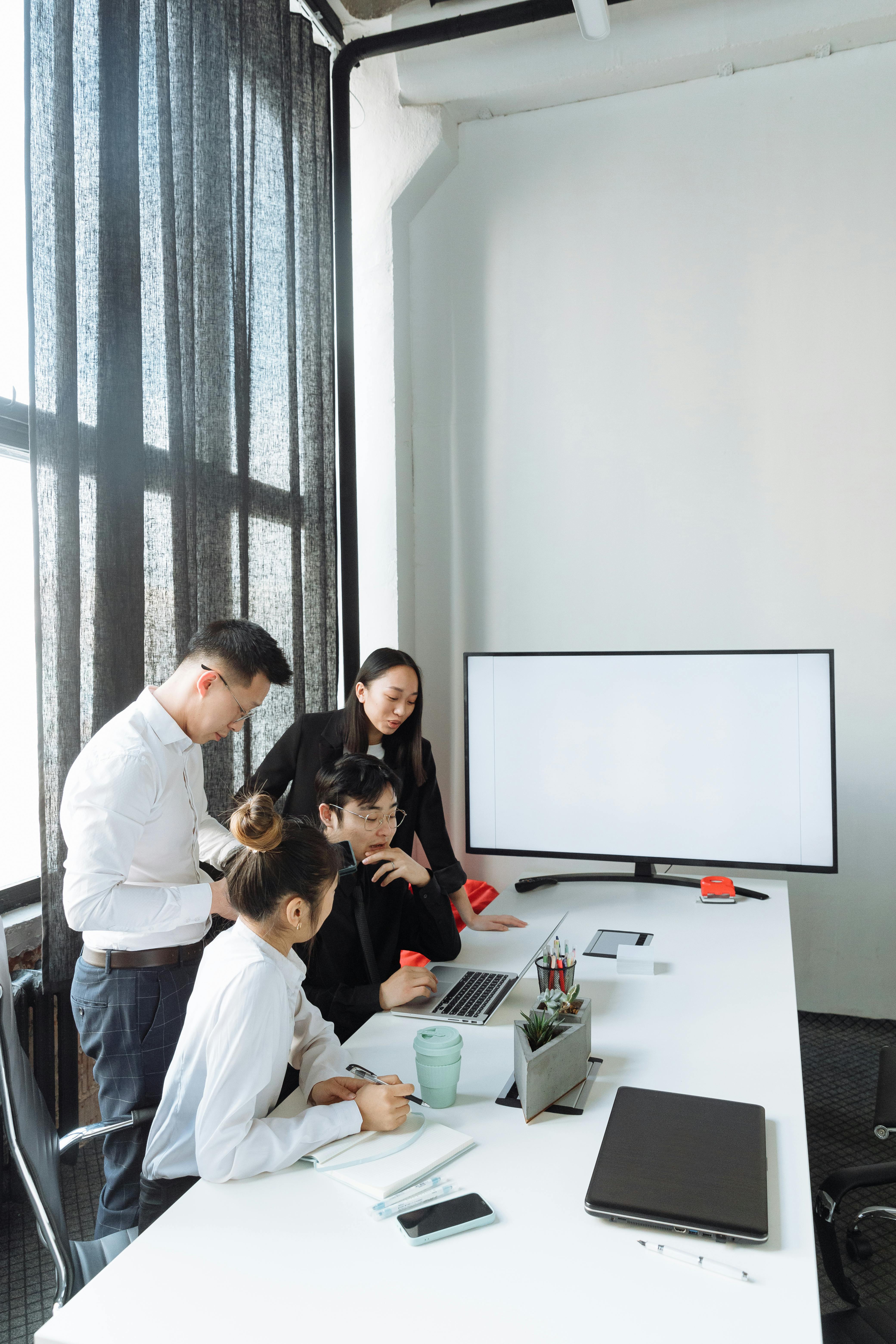 A team of people smiling sitting at computers